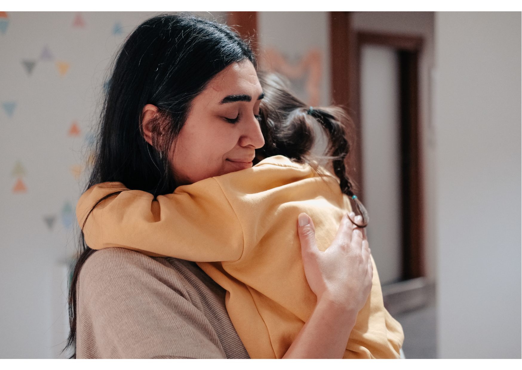Madre abrazando a su hija en su hogar